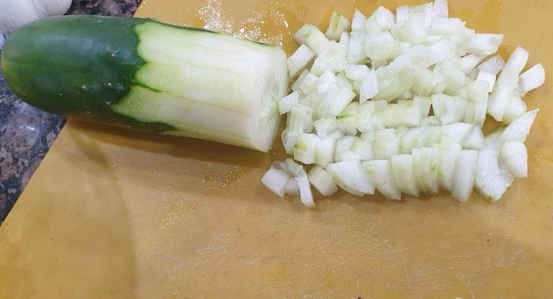 Place the diced cucumber and place into the food processor.  This will add some of the water needed to loosen up the consistency of the tzatziki sauce.