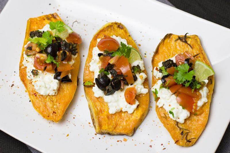 Sweet potatoes topped with goat cheese, olives, tomatoes and cilantro is a great meal filled with complex carbohydrates and micro-nutrients.