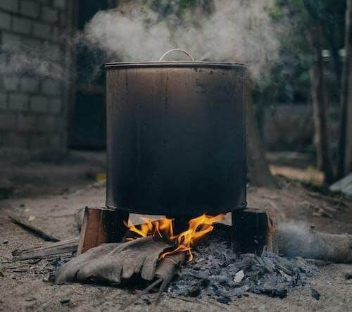 The black soap ingredients are roasted in a pot over an open fire.