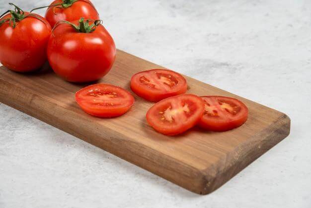 Sliced or diced tomatoes add a fresh and juicy element to a fish paste sandwich.