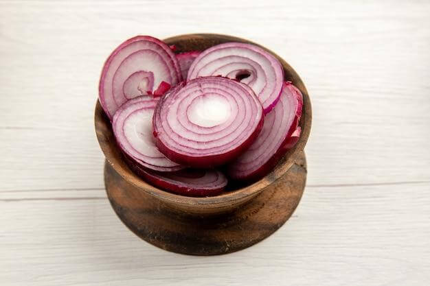 Thinly sliced red onion adds a sharp and zesty kick to a fish paste sandwich.