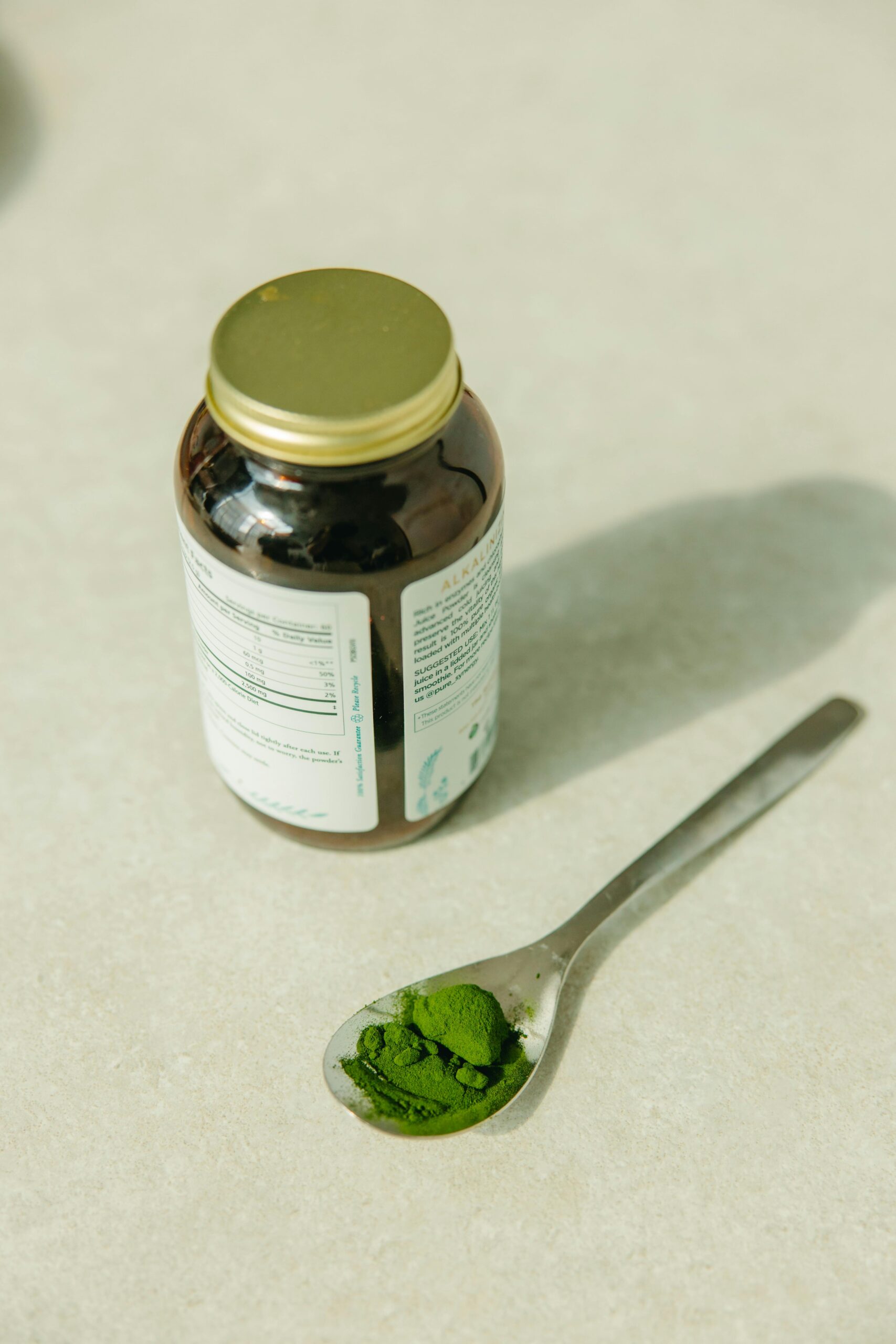 Green chlorella powder in a wooden spoon on a table