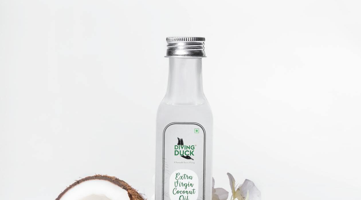 Coconut oil jar with fresh coconut and white flowers