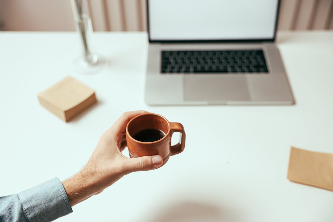 Person holding coffee during a pomodoro break for deep work