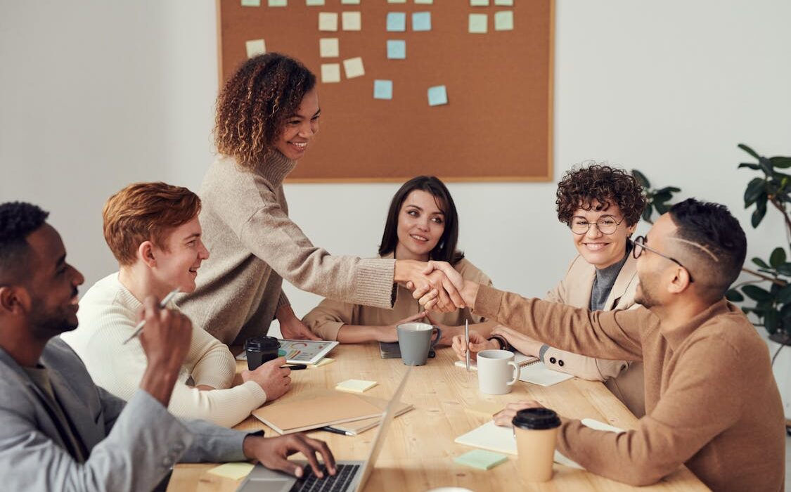 People working together at a shared desk for body doubling focus