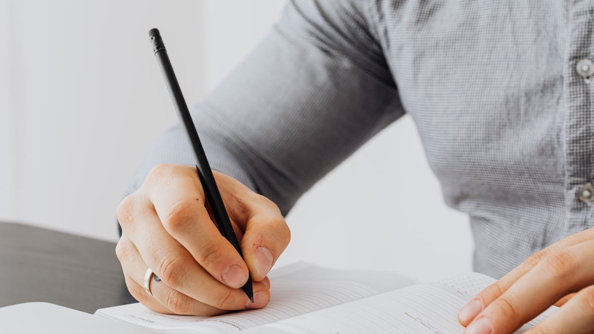 Notebook open to a blank page next to a closed laptop, with phone out of reach, set up for a focus session