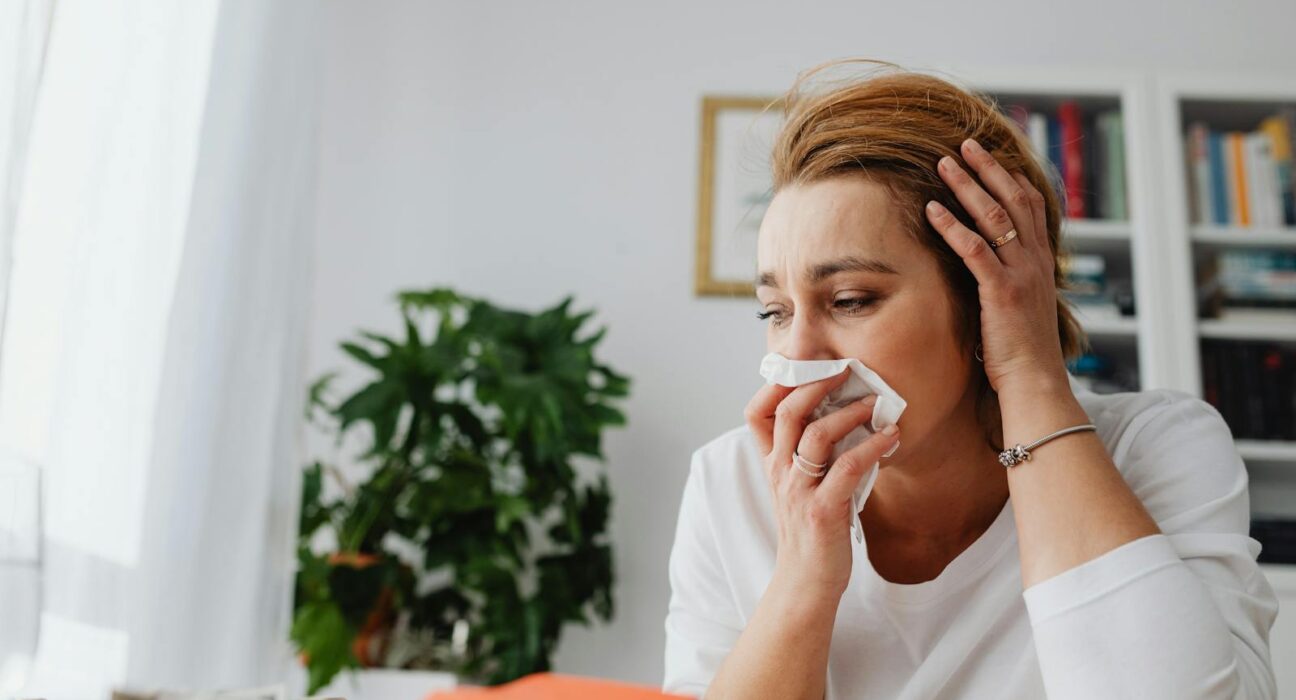 Woman with seasonal allergies blowing her nose