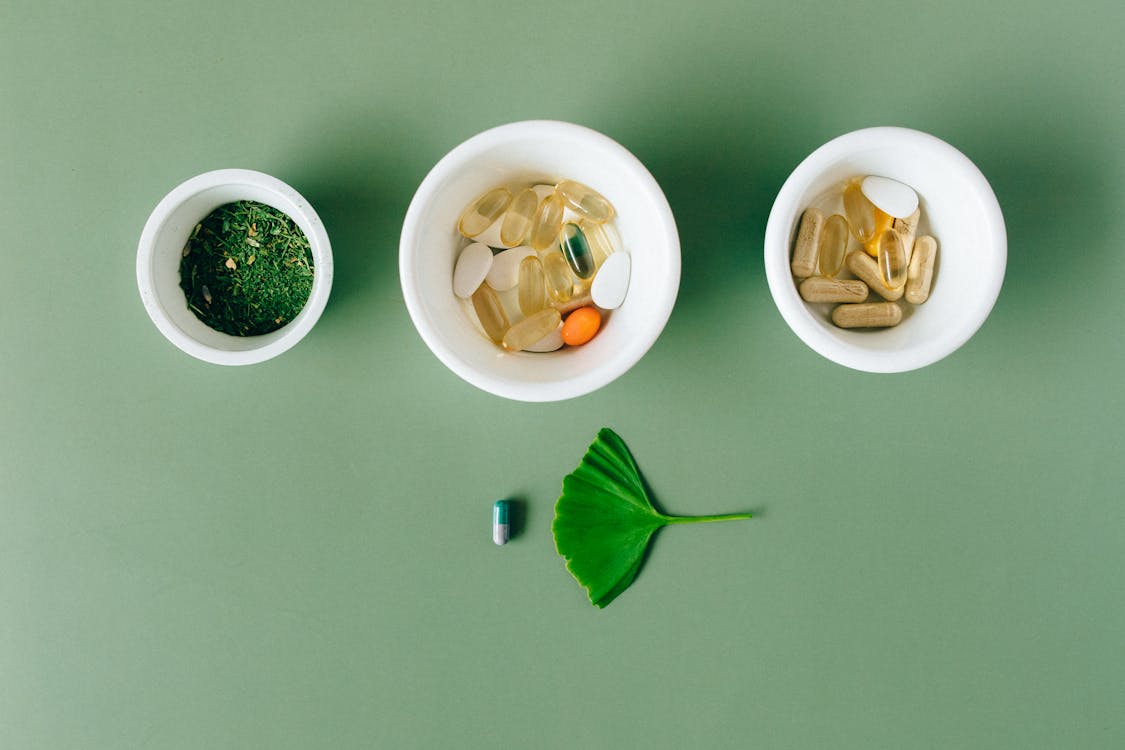 Herbal supplements and capsules in ceramic bowls for natural wellness
