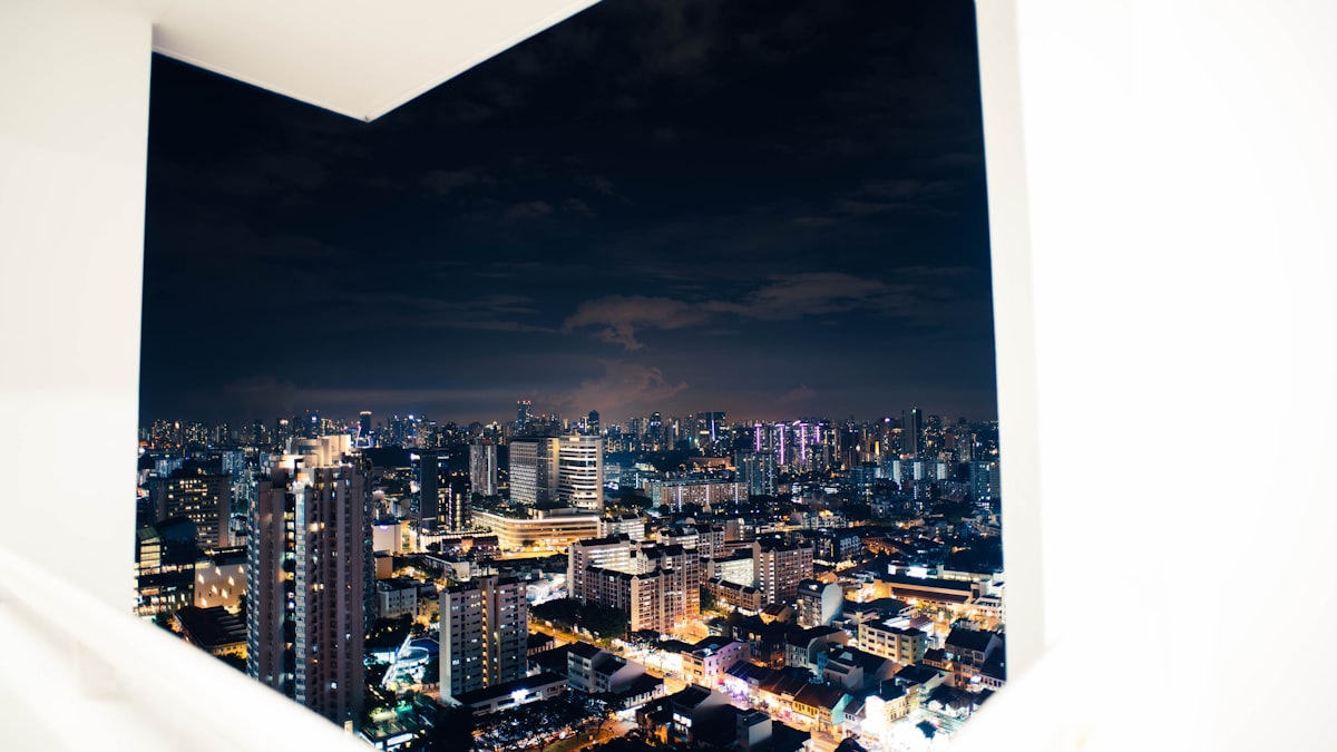 Looking out at city lights from a highrise window at night