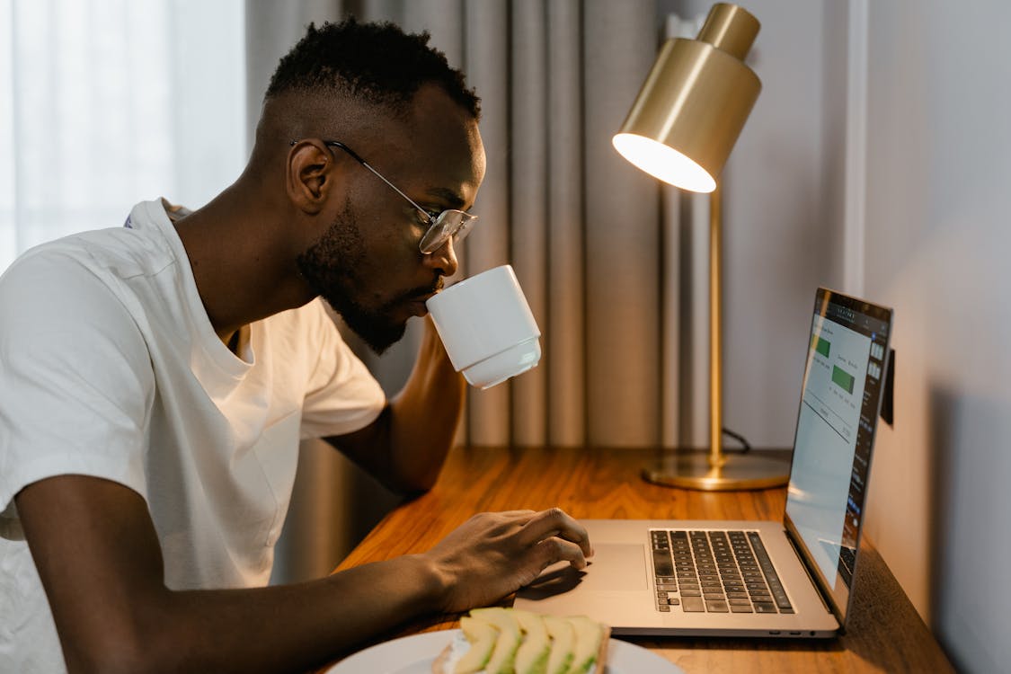 Man drinking coffee while working from home on important tasks