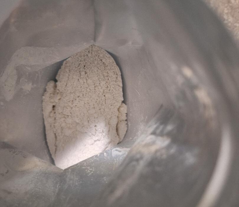 Looking down into an open bag of Cultivate Elevate freshwater pearl powder, showing the soft white mineral powder inside