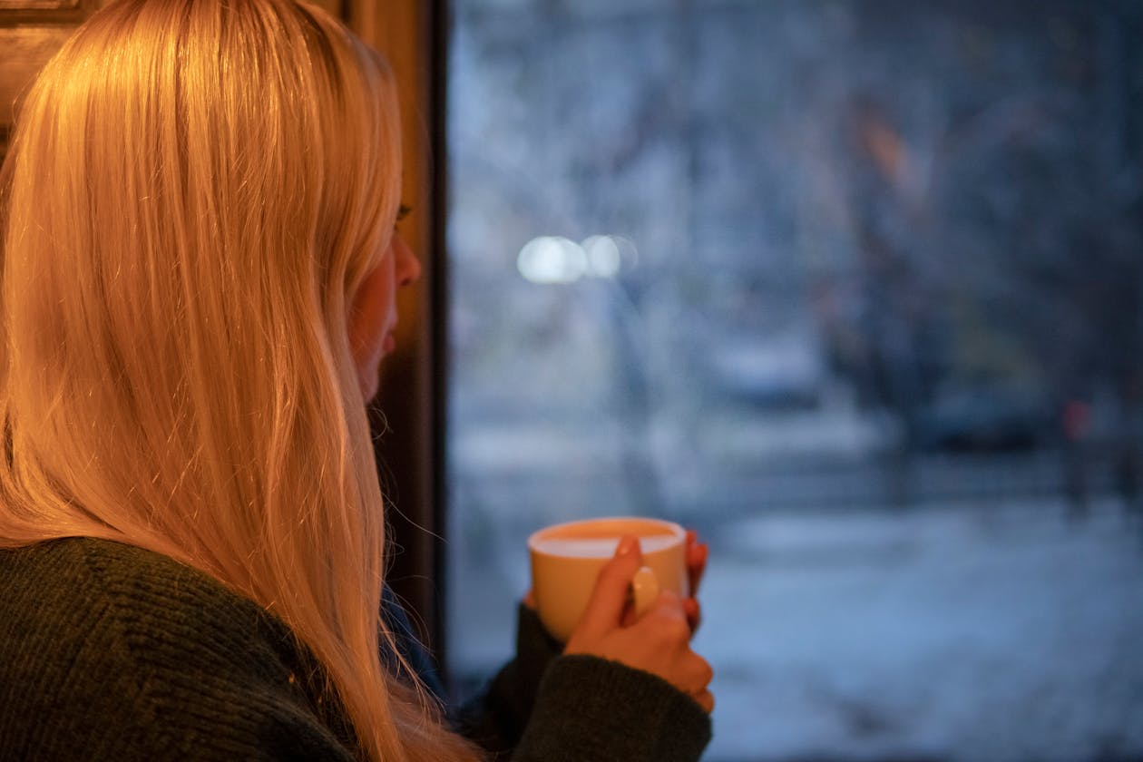 Woman looking out window practicing the 5-4-3-2-1 grounding technique for anxiety