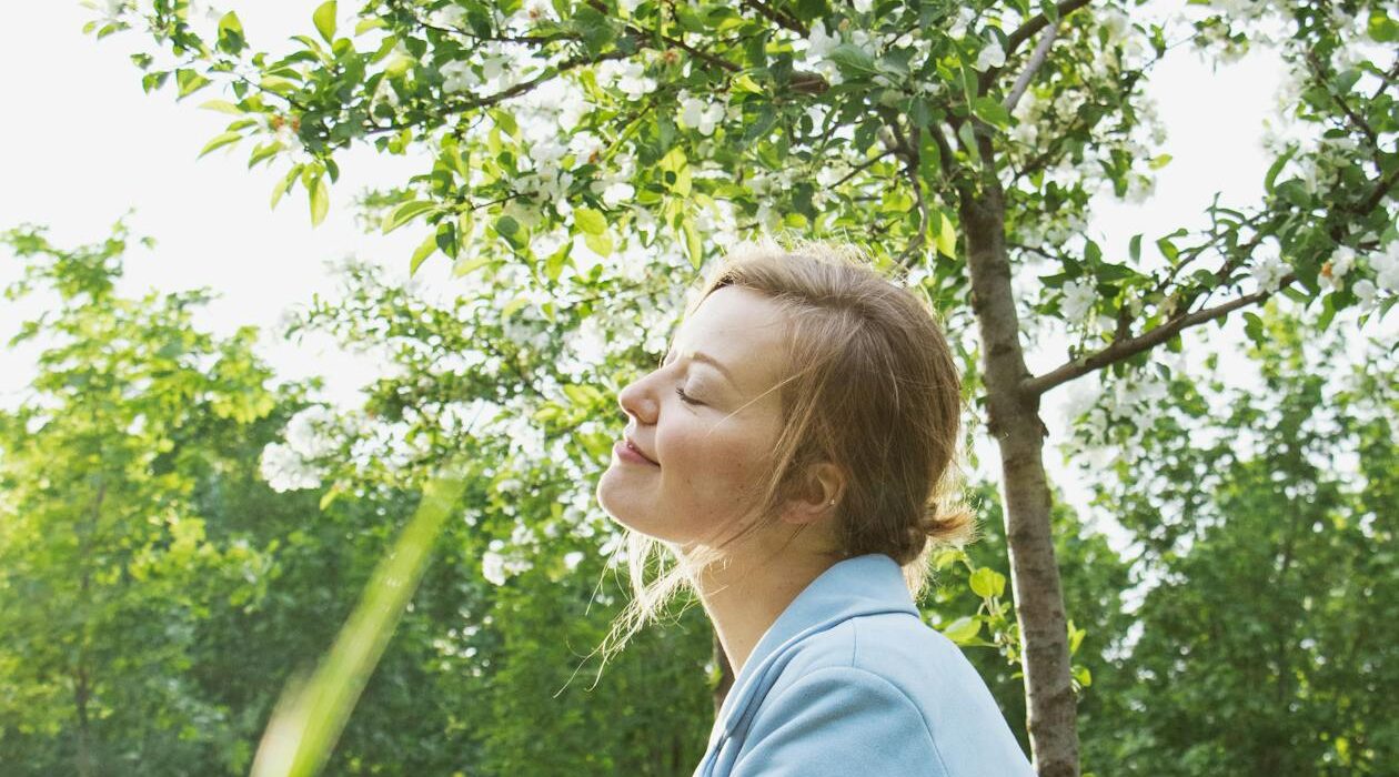 Woman sitting peacefully outdoors using the 5-4-3-2-1 grounding technique for anxiety