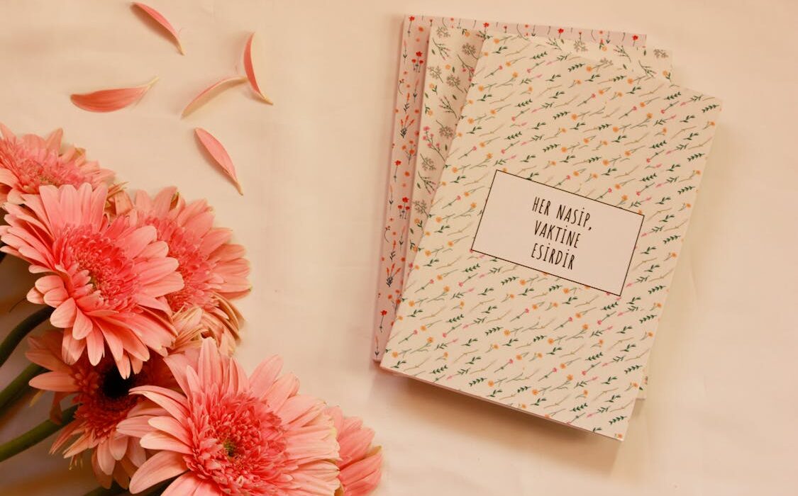 pink flowers beside notebook journals for spring reset journaling mindfulness