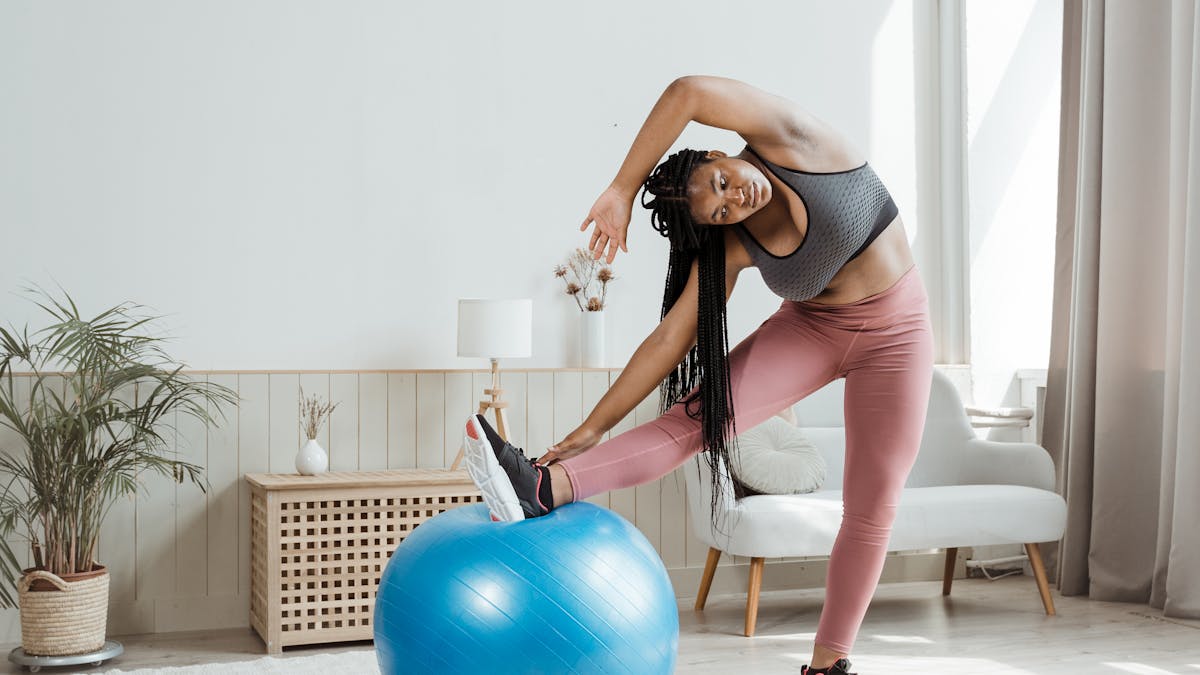 Woman stretching before a rebounding session for lymphatic flow