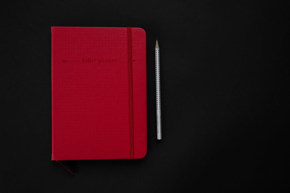 Planner with red pencil representing the two minute rule for procrastination