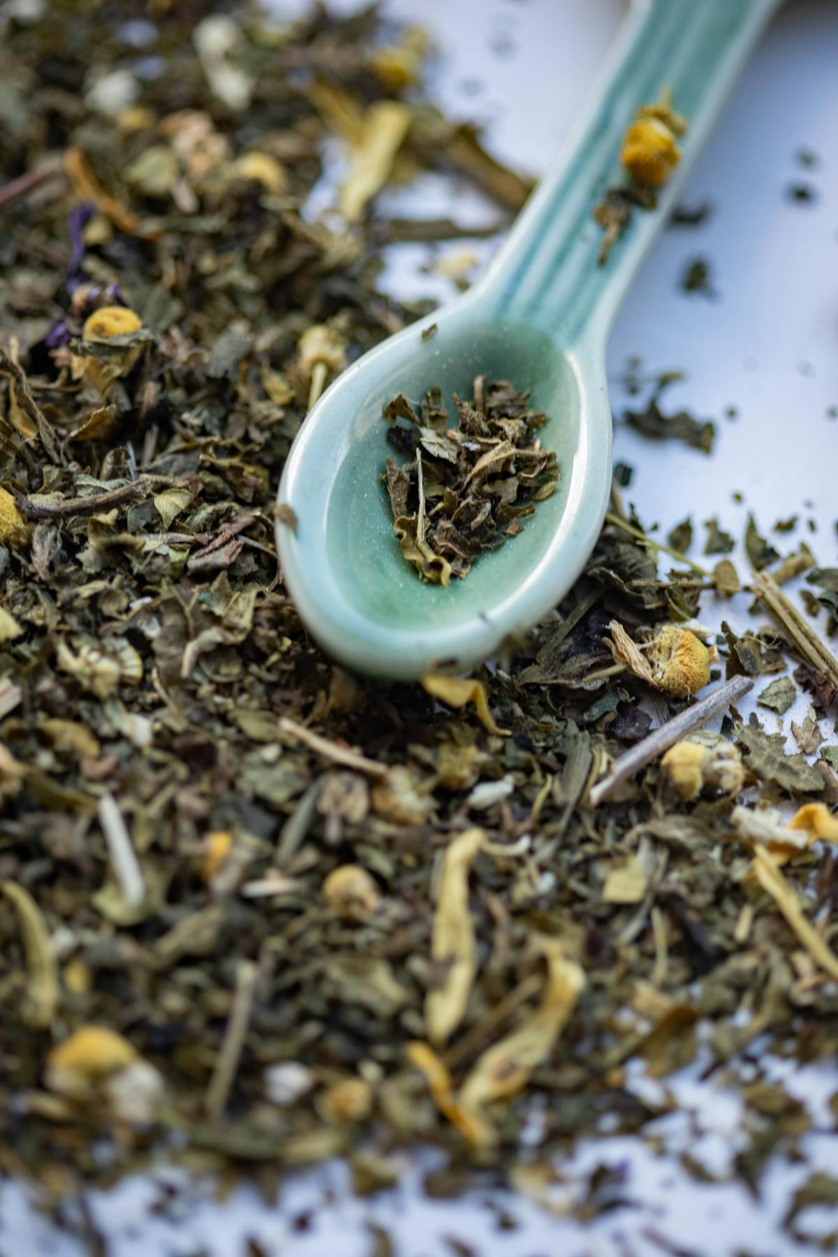 Loose mullein leaves with a small ceramic spoon ready for brewing
