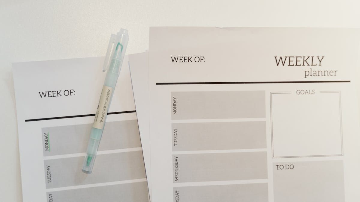 Weekly review practice planner open with a black pen for Sunday planning
