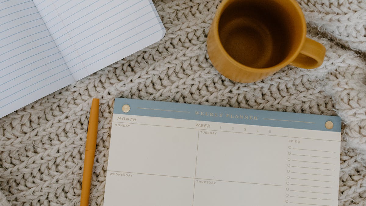 Sunday weekly review practice setup with planner and coffee