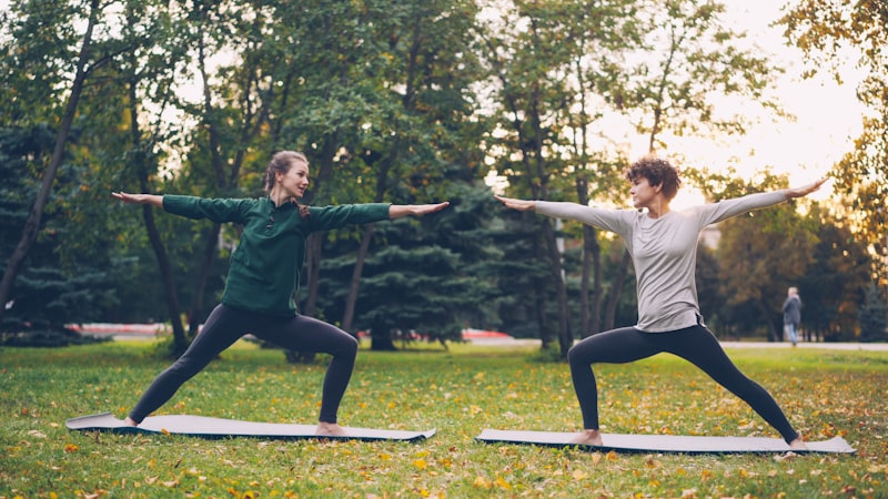 Women practicing yoga outdoors in a park for stress management and gut health