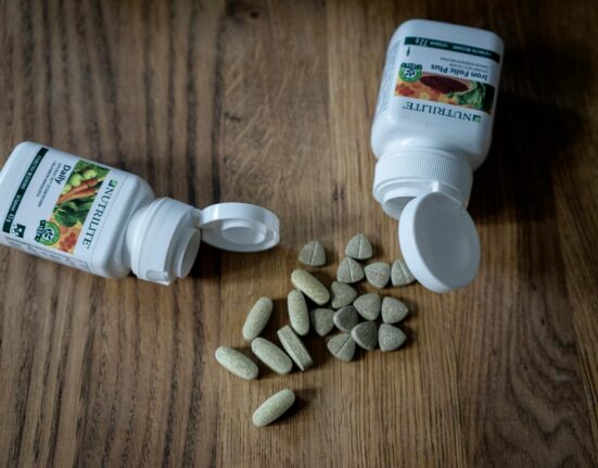 Parasite cleanse herbs cloves wormwood and black walnut hulls on a wooden table with a glass of water
