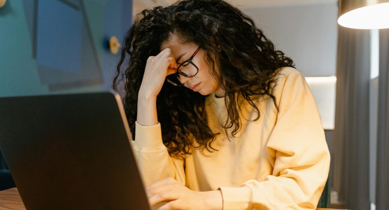 Woman with mental fatigue at her desk in a sunlit home office