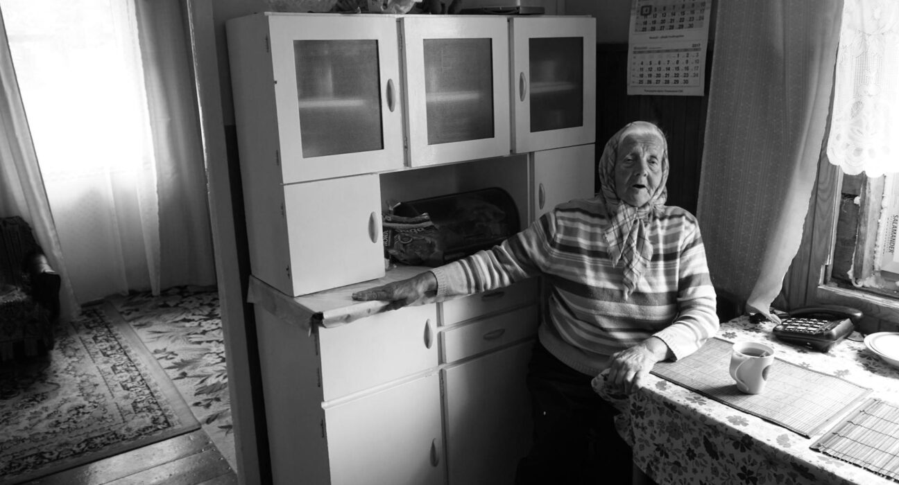 Older woman thoughtfully checking a calendar at a kitchen table