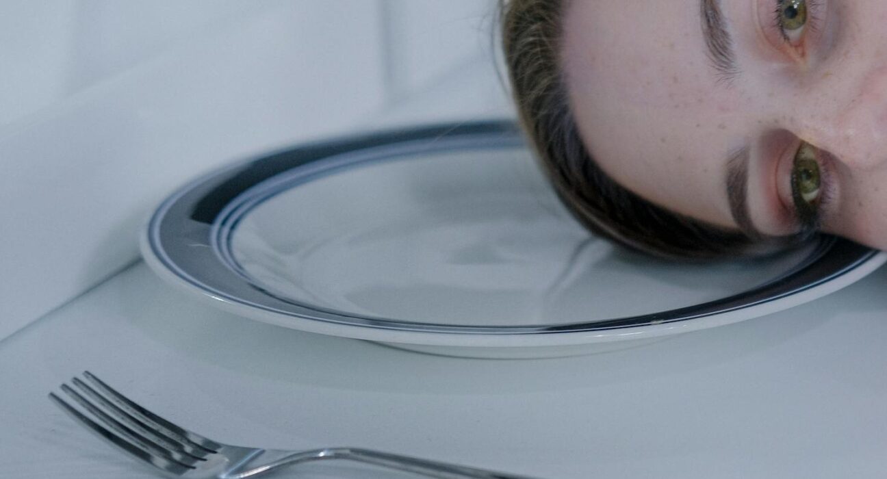 Woman feeling tired and still hungry after a meal