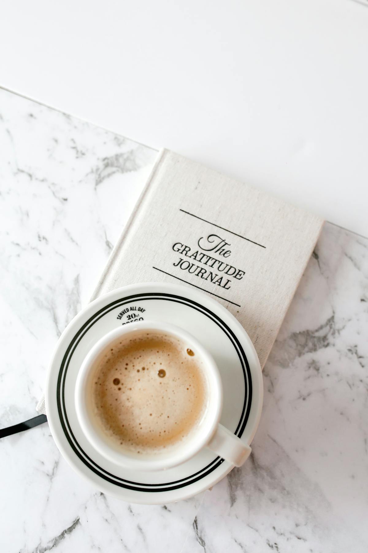 A 5 minute gratitude journal beside a coffee cup on a peaceful morning desk