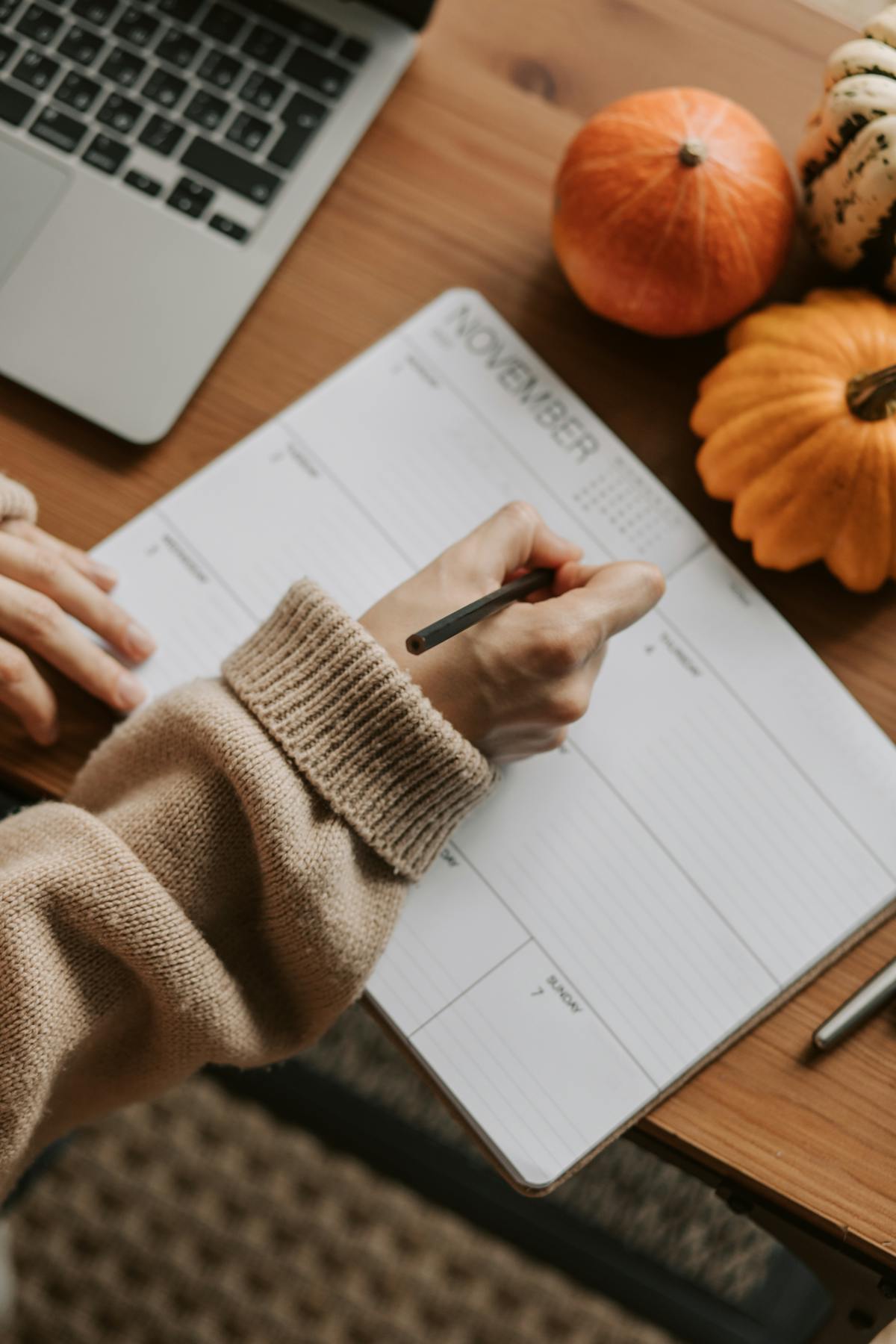 Hand writing in a calendar planning a Sunday reset routine for the week ahead