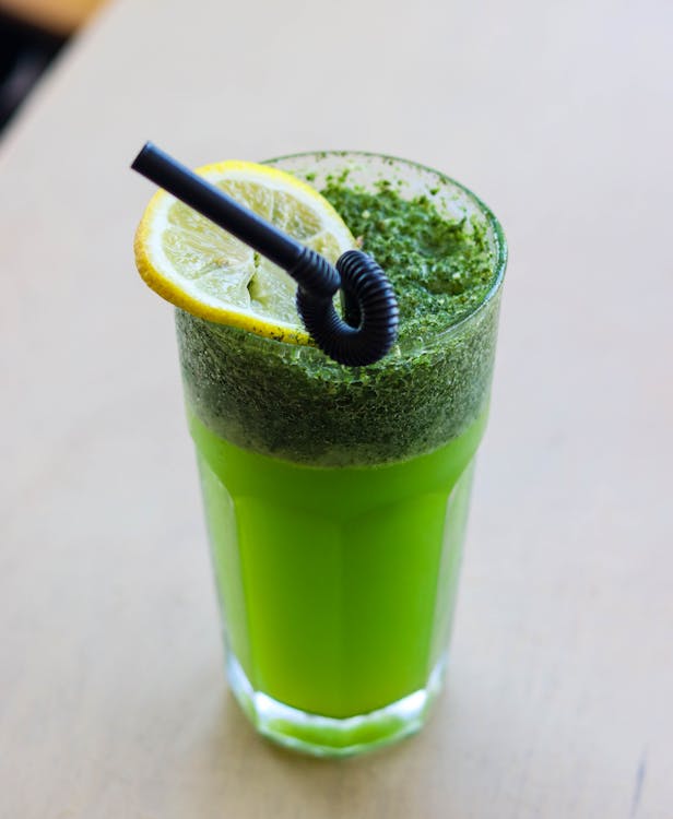 Fresh green chlorophyll juice bottle with ginger and lemon