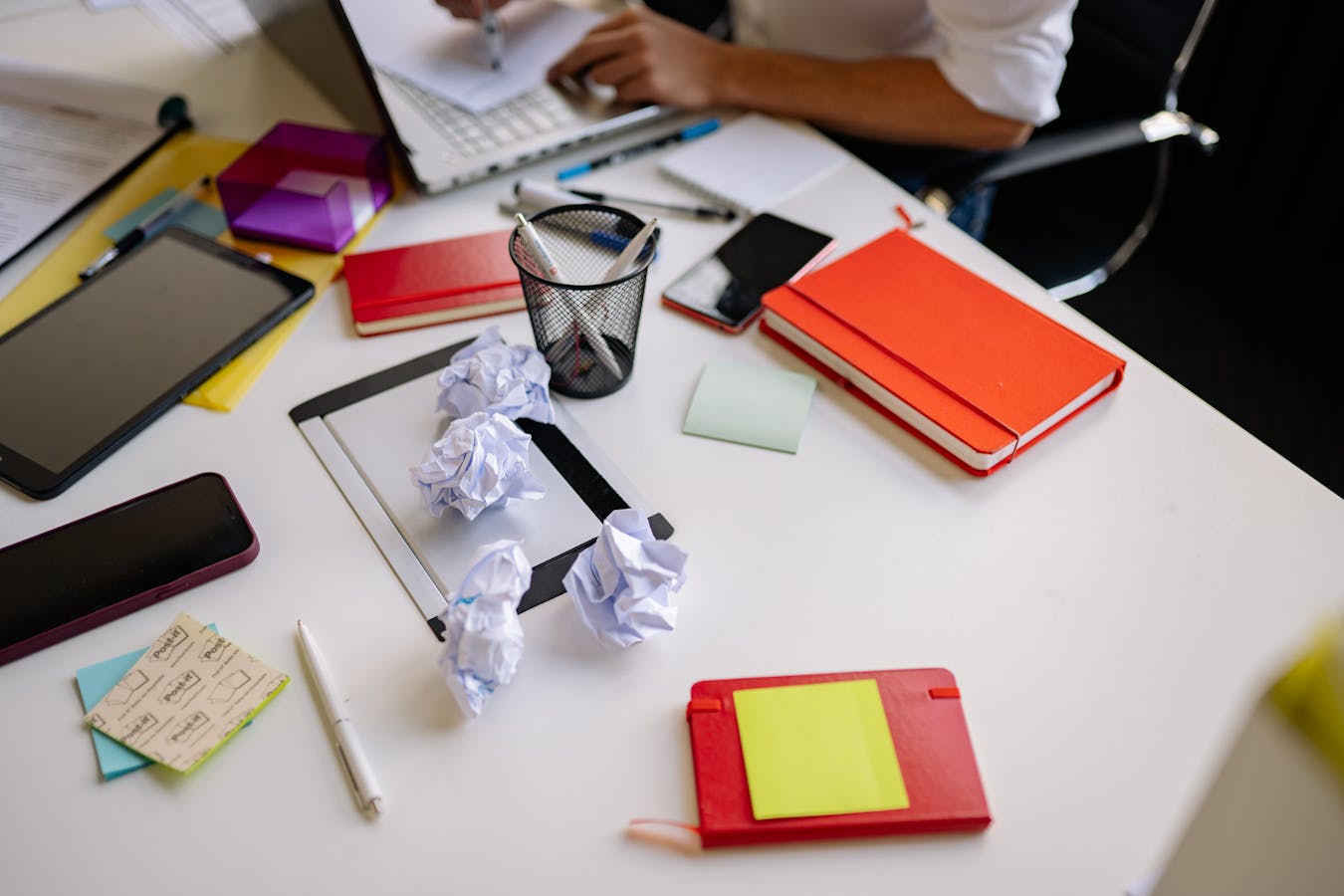 Cluttered desk with crumpled papers showing procrastination overwhelm