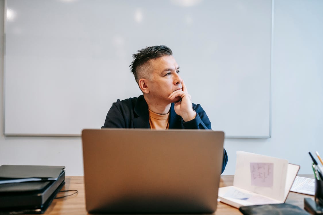 Person thinking carefully before writing in decision journal