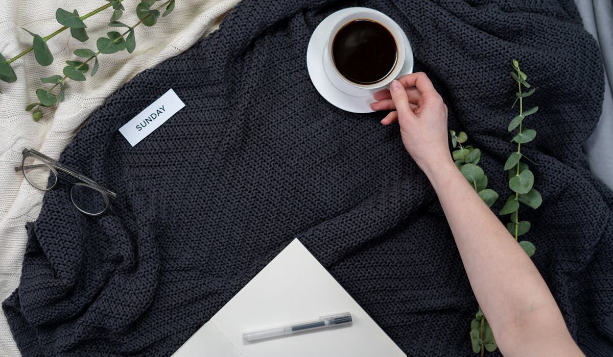 Cozy Sunday morning setup with coffee and notebook for a Sunday reset routine