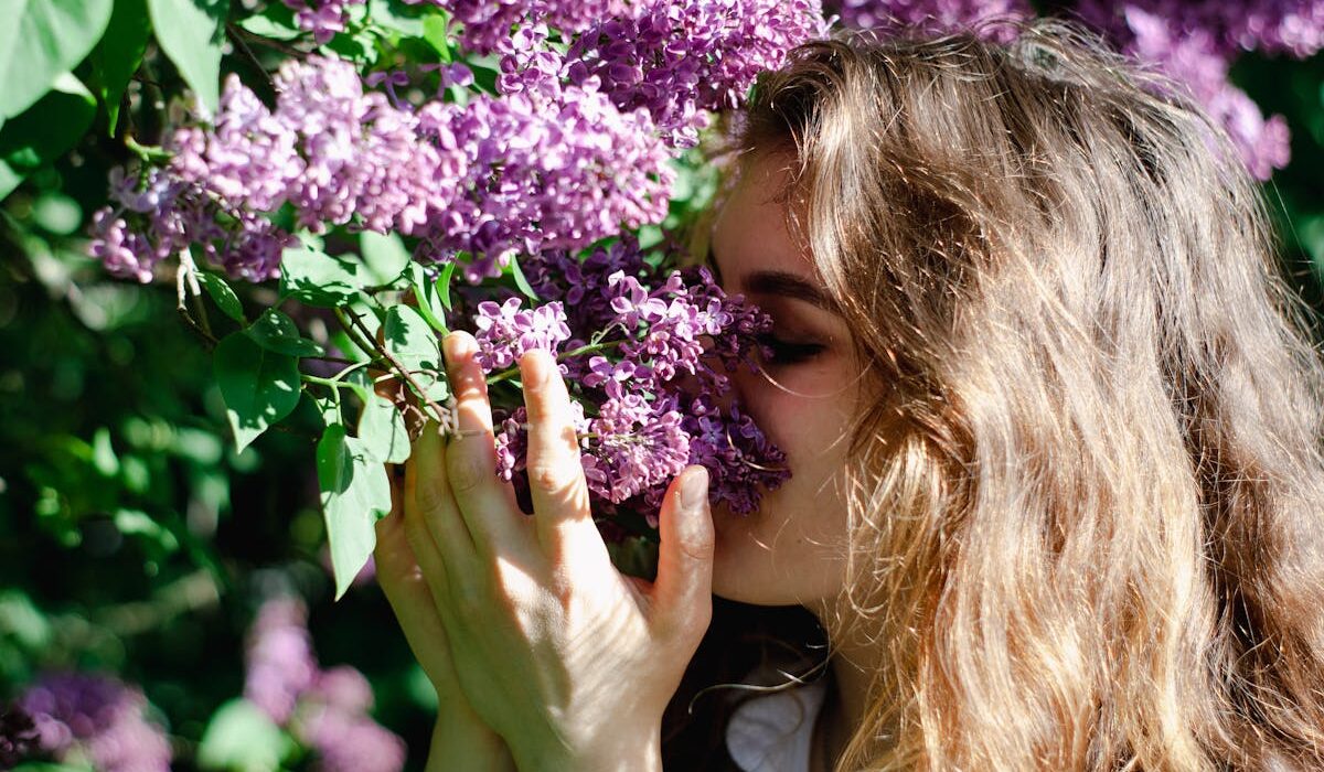 Woman smelling spring flowers with elderberry syrup for spring allergies in mind