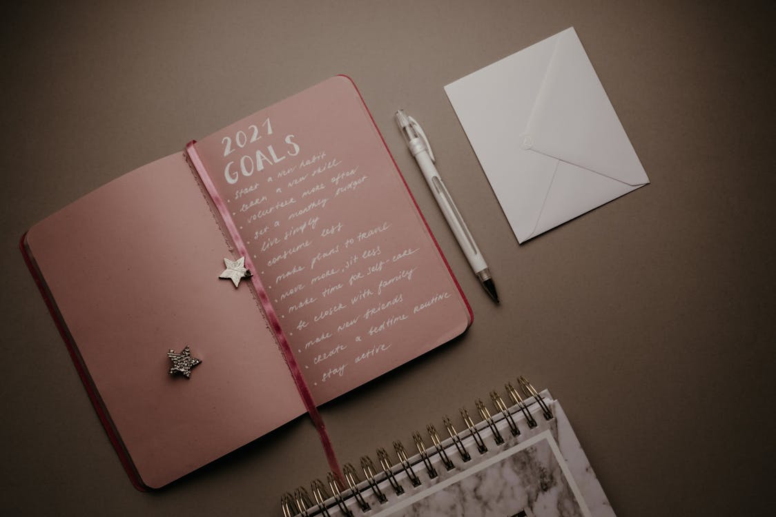 Five minute journal vs bullet journal comparison open on a desk with pen