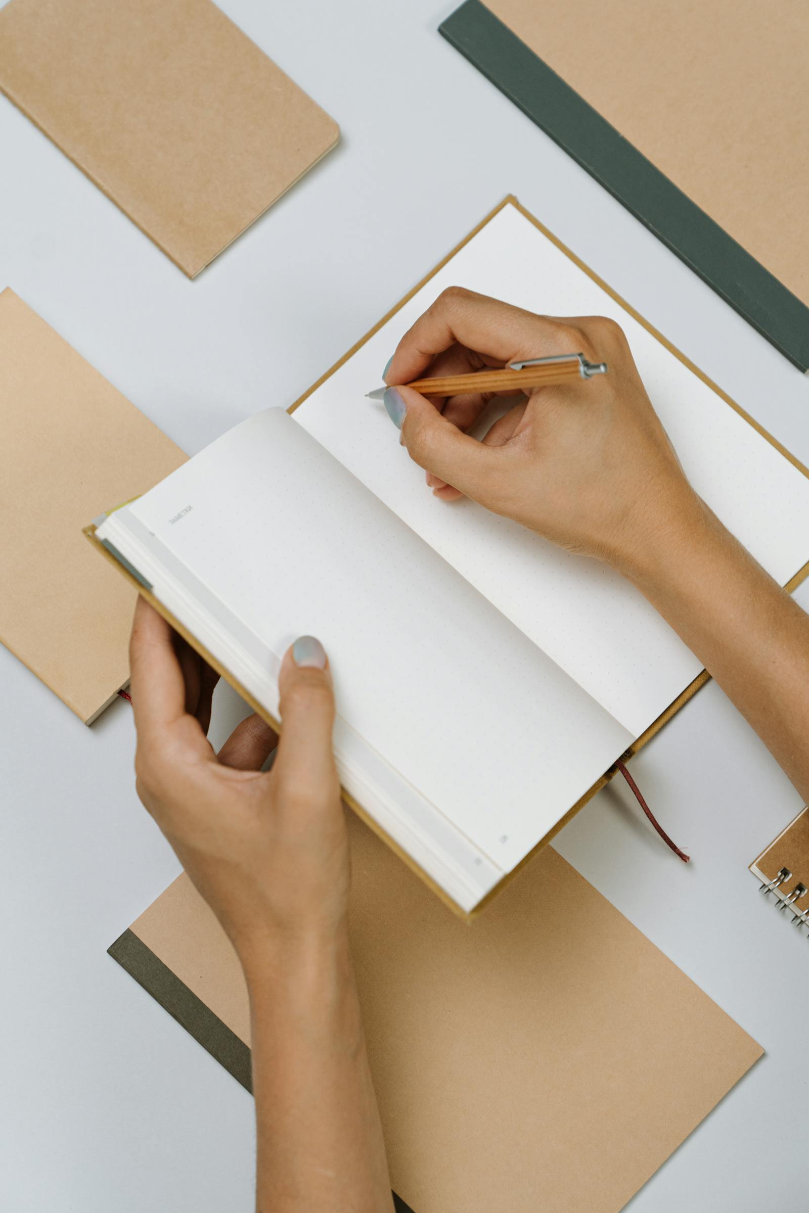 Hands writing in a journal as part of habit stacking for beginners