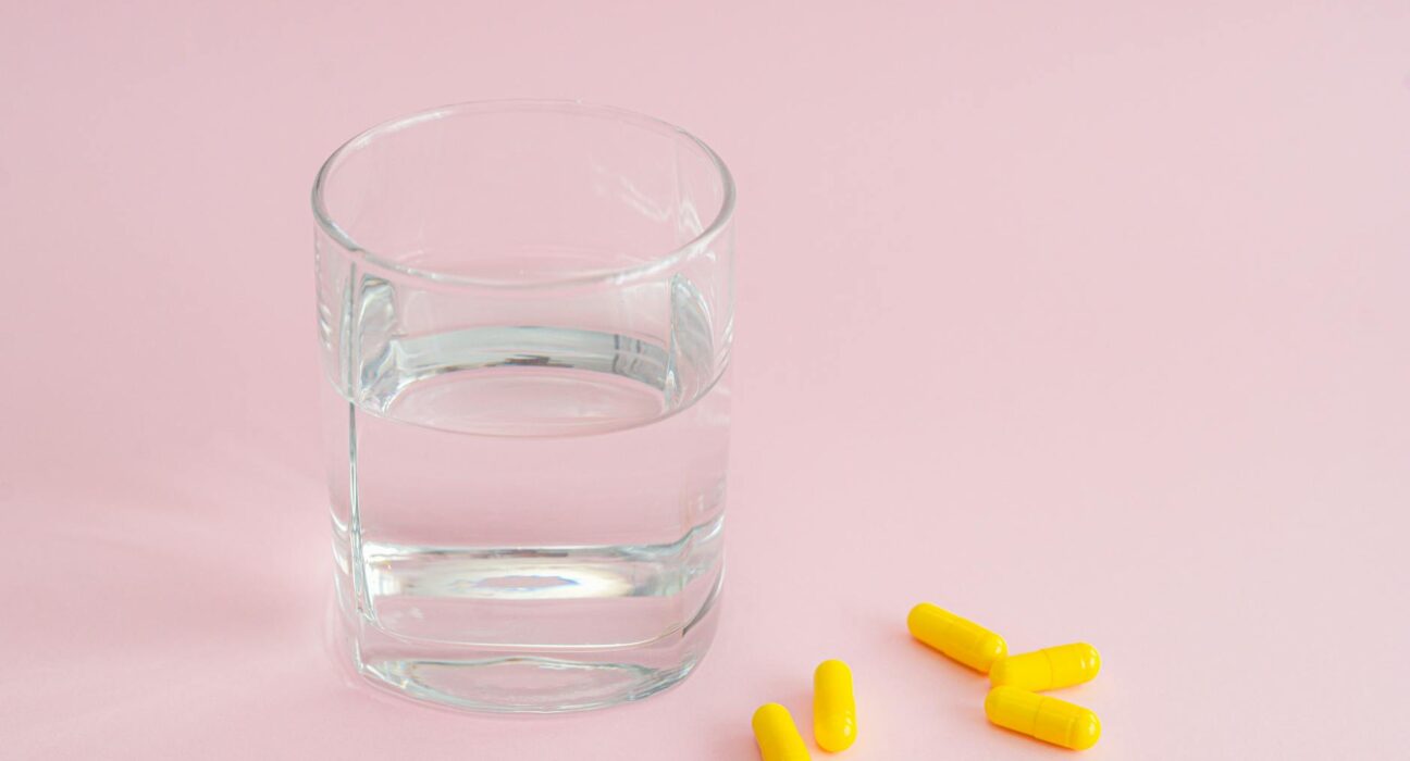 Magnesium supplement capsules beside glass of water