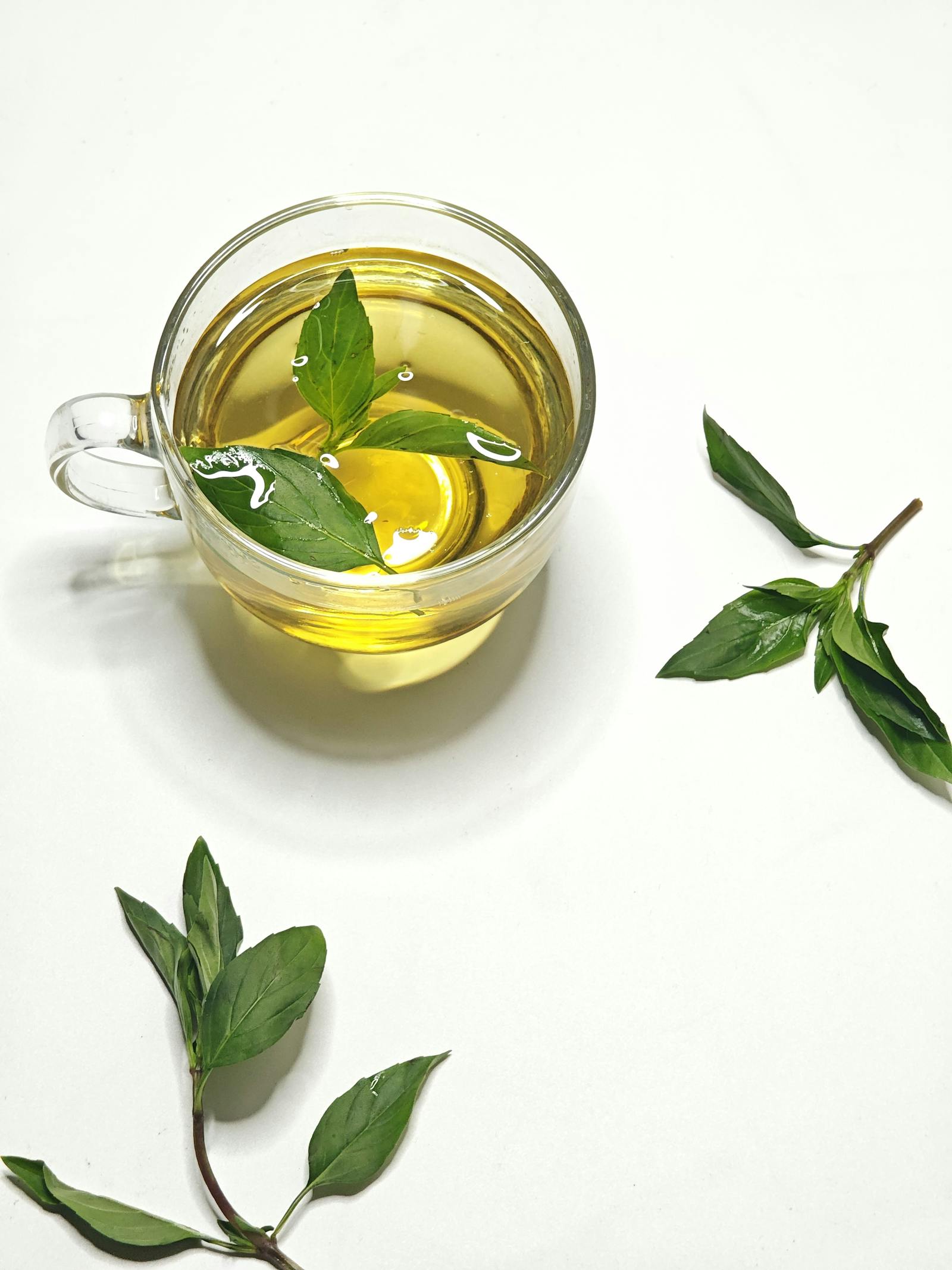 Holy basil tea steeping in a clear glass cup
