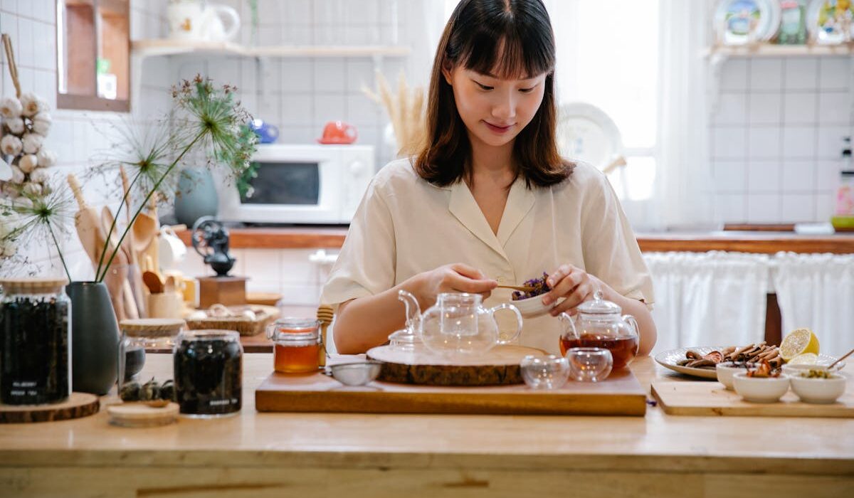 Parasite cleanse at home woman preparing herbal tea in cozy kitchen