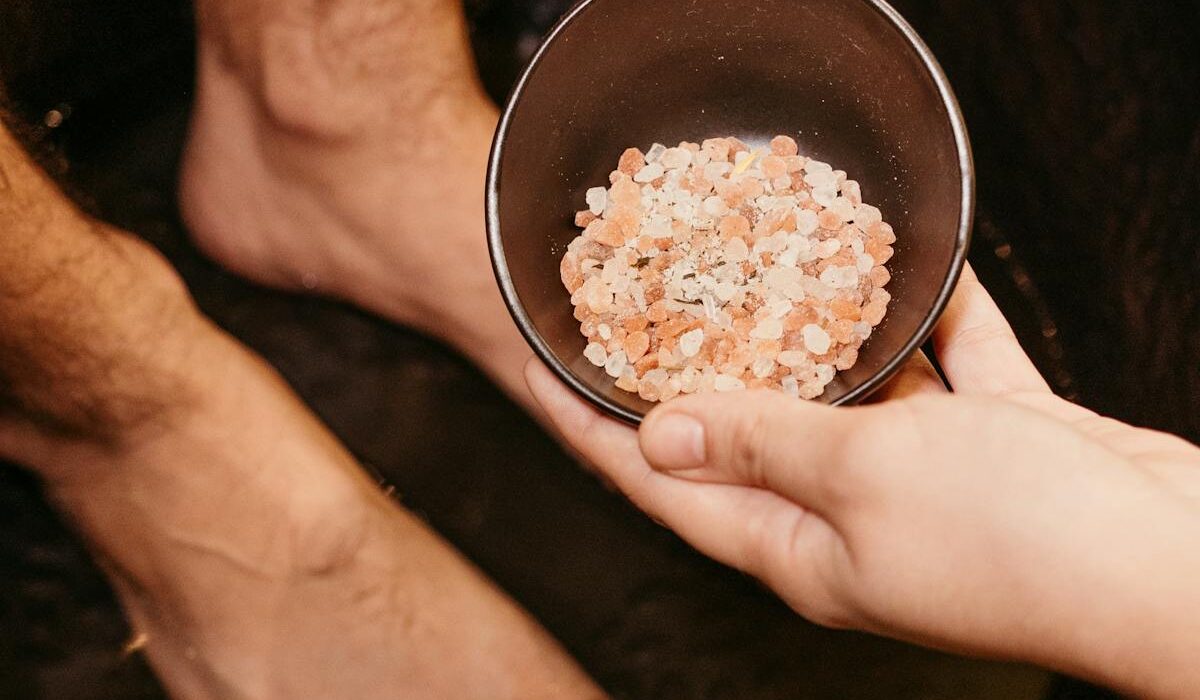 Epsom salt foot soak benefits feet in basin with pink bath salts
