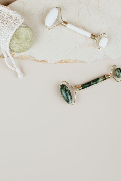 Flat lay of jade rollers for terahertz wand vs rose quartz roller skincare routine