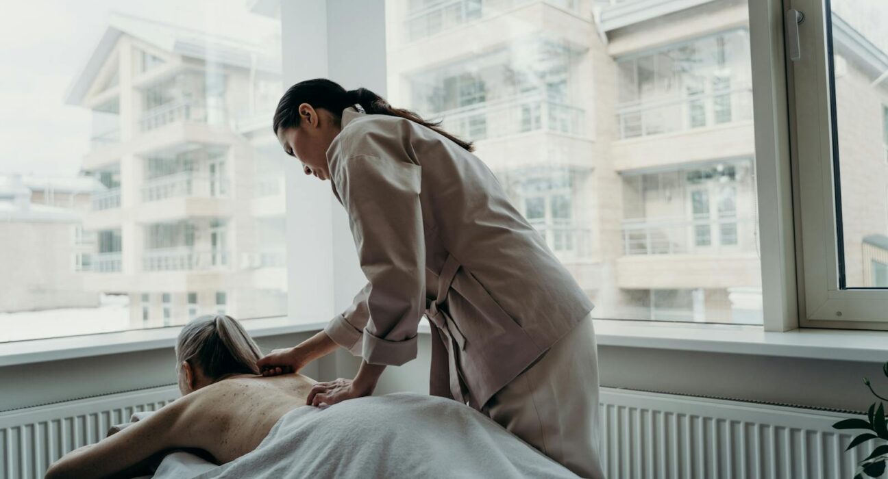 Woman receiving a professional lymphatic drainage massage on her back in a calm spa setting