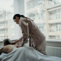 Woman receiving a professional lymphatic drainage massage on her back in a calm spa setting