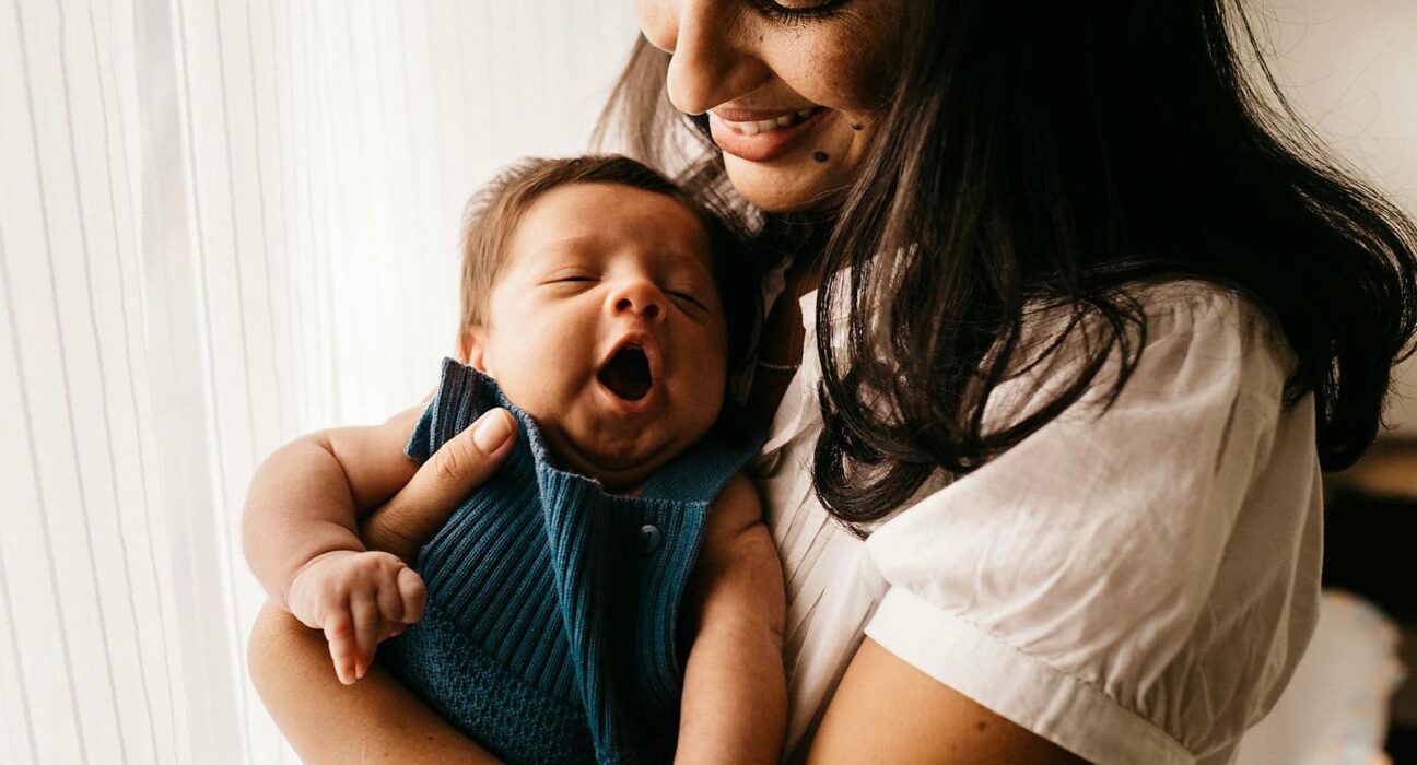 Modest portrait of mother holding newborn baby thinking about parasite cleanse while breastfeeding