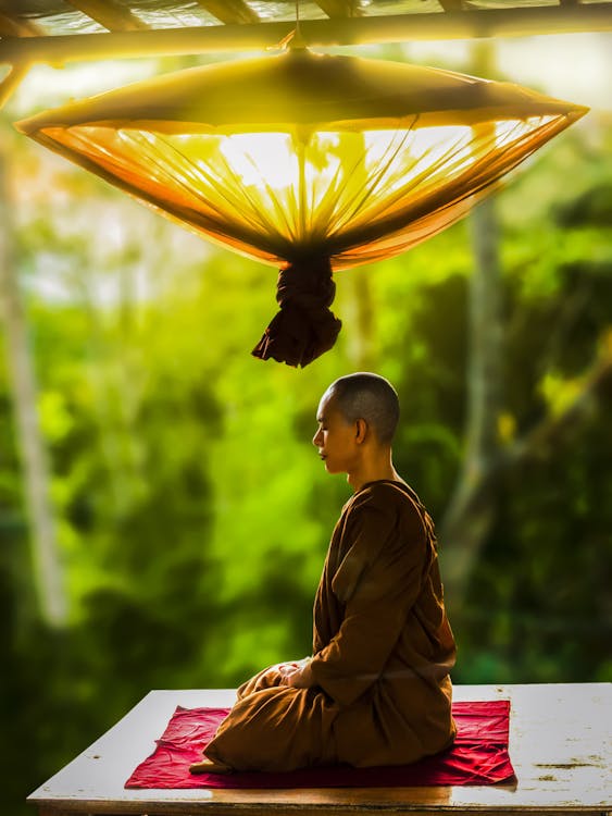 Person meditating outdoors in the morning sun for natural dopamine support
