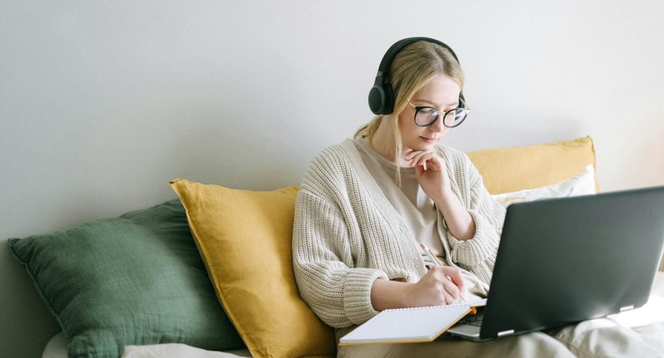 woman at desk with laptop and notebook applying pareto principle for daily productivity