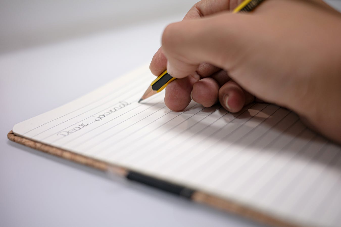 Hand writing a small two-minute task in a notebook for daily productivity