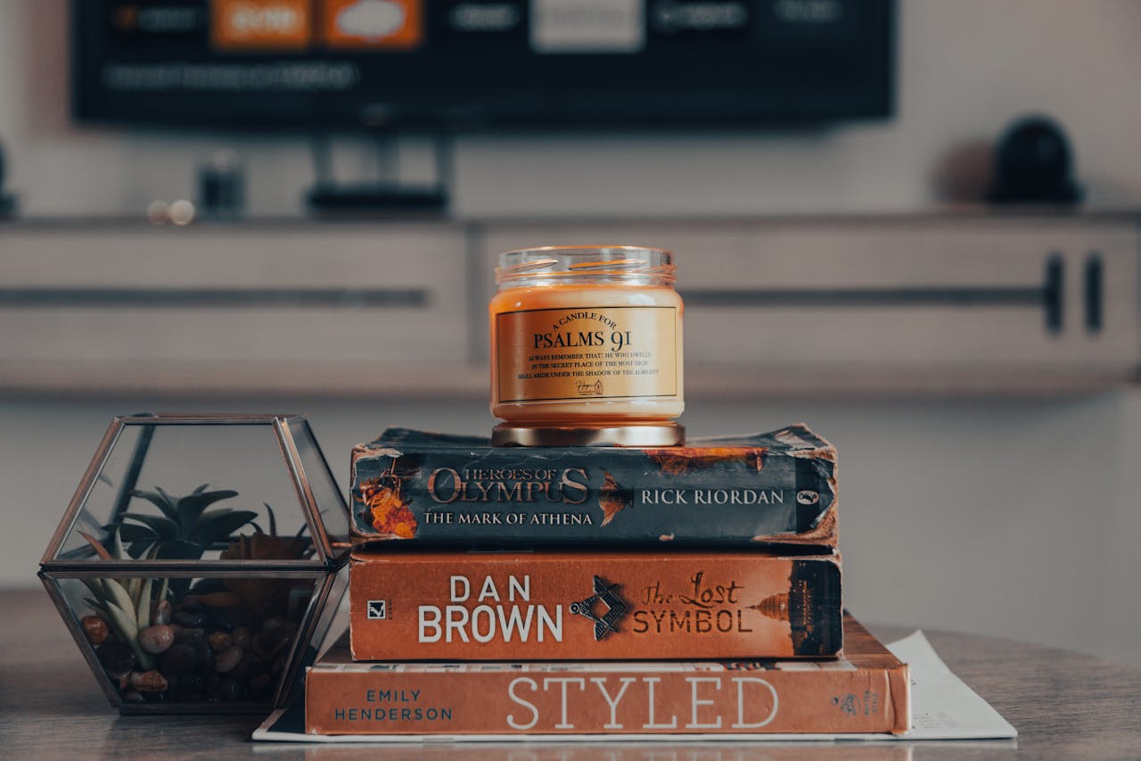Stack of books and a lit candle for an evening reading wind-down