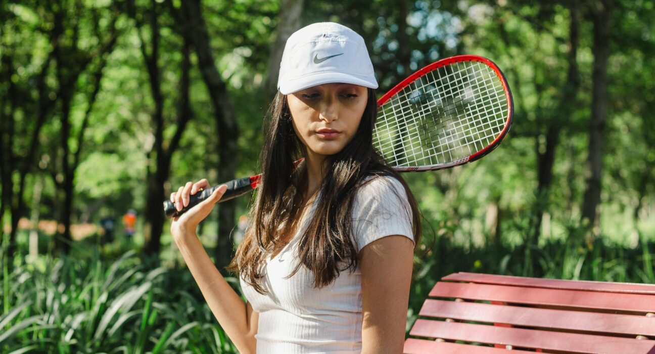 Active woman playing tennis confidently outdoors, demonstrating impact-friendly ostomy support
